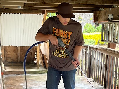 Man with a funky monkey t shirt pressure washing a patio